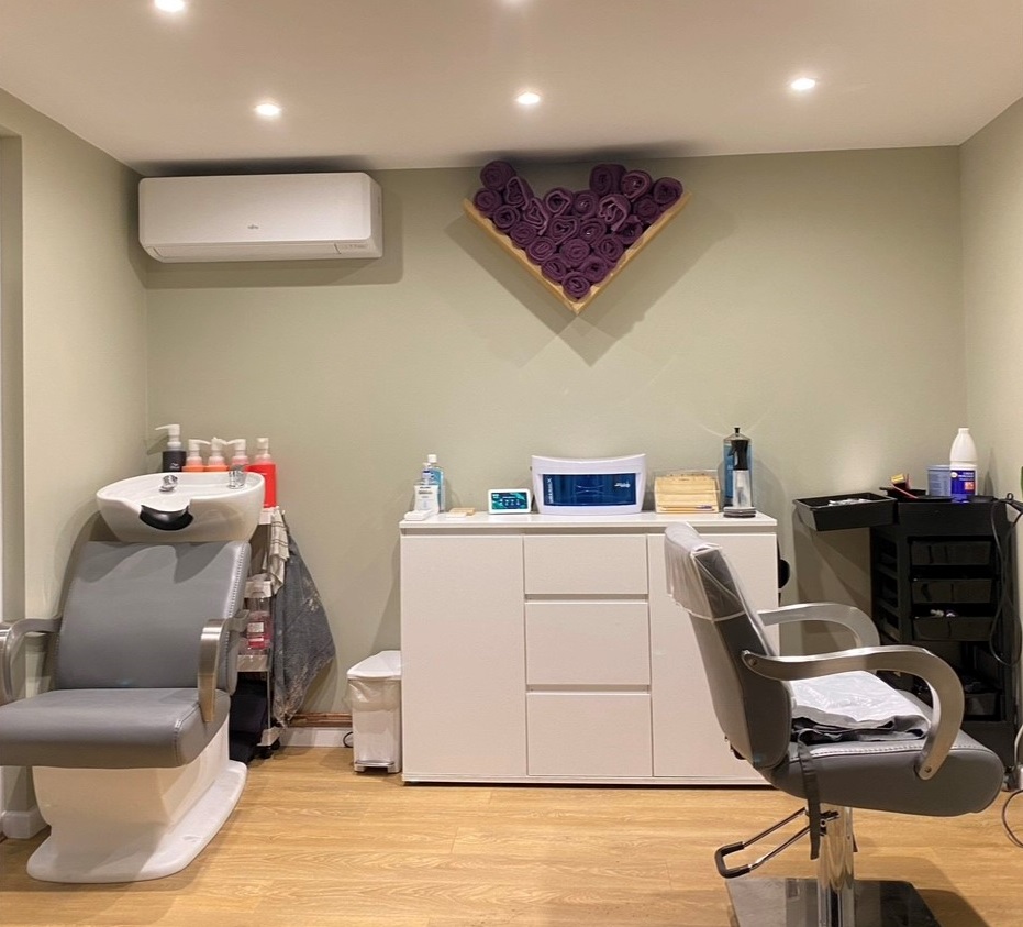 Salon interior. Hairdressing chair and basin. Storage unit and products.